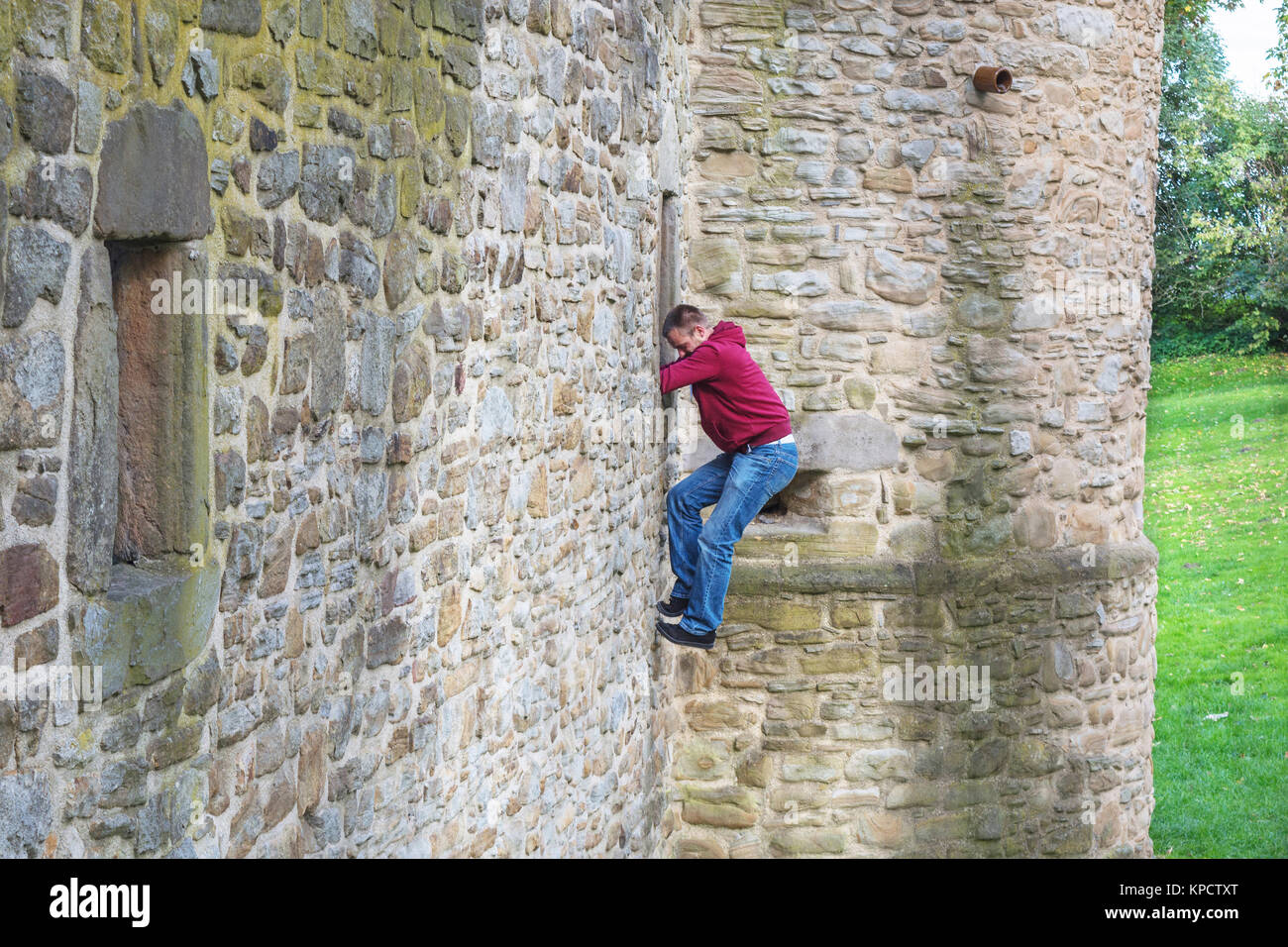 man climbs up a castle wall. Stock Photo