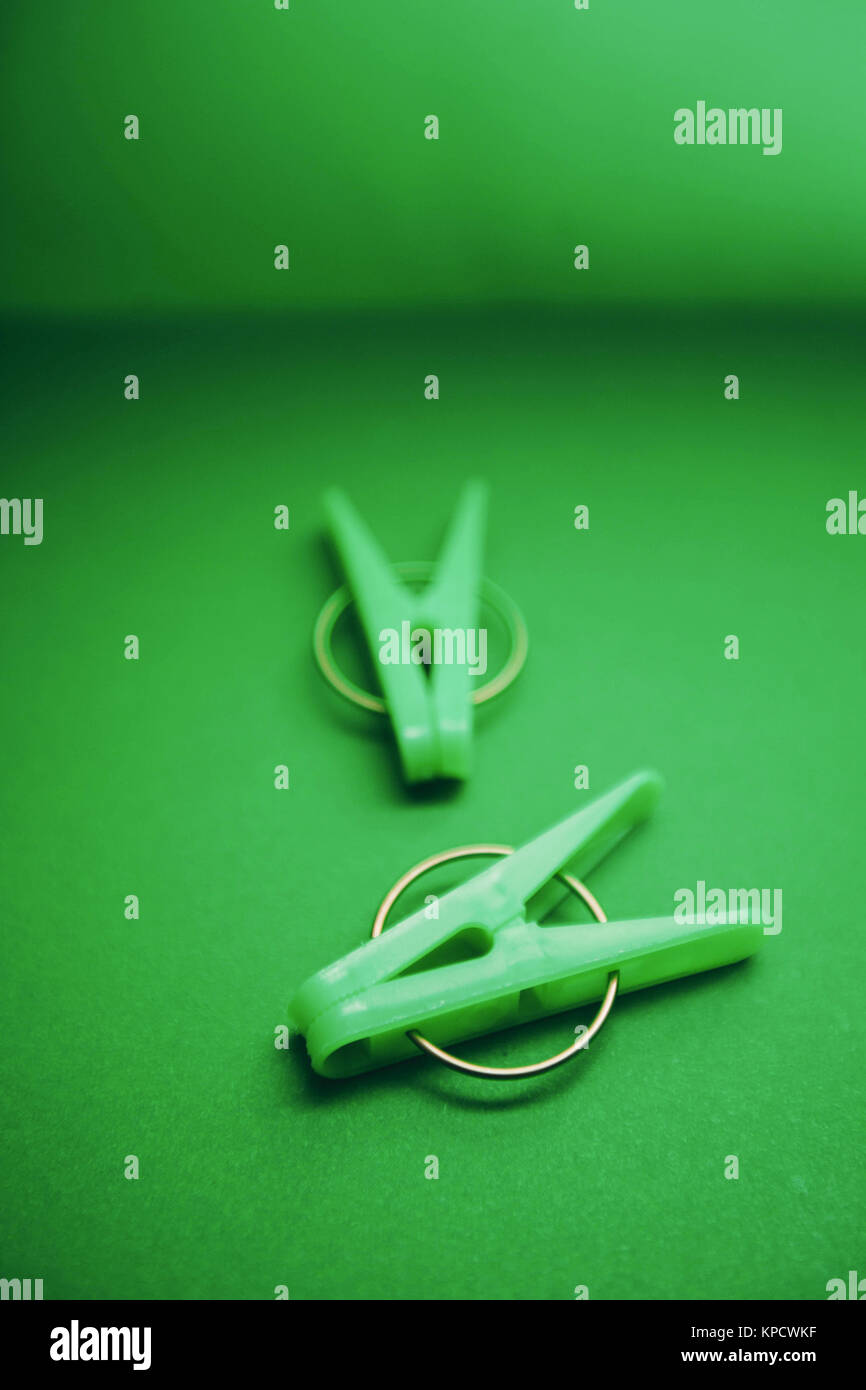 Green plastic clothes clothes pegs on a bright one-color green background. Top view. Blurred background. Household supplies isolated. top view. Close  Stock Photo