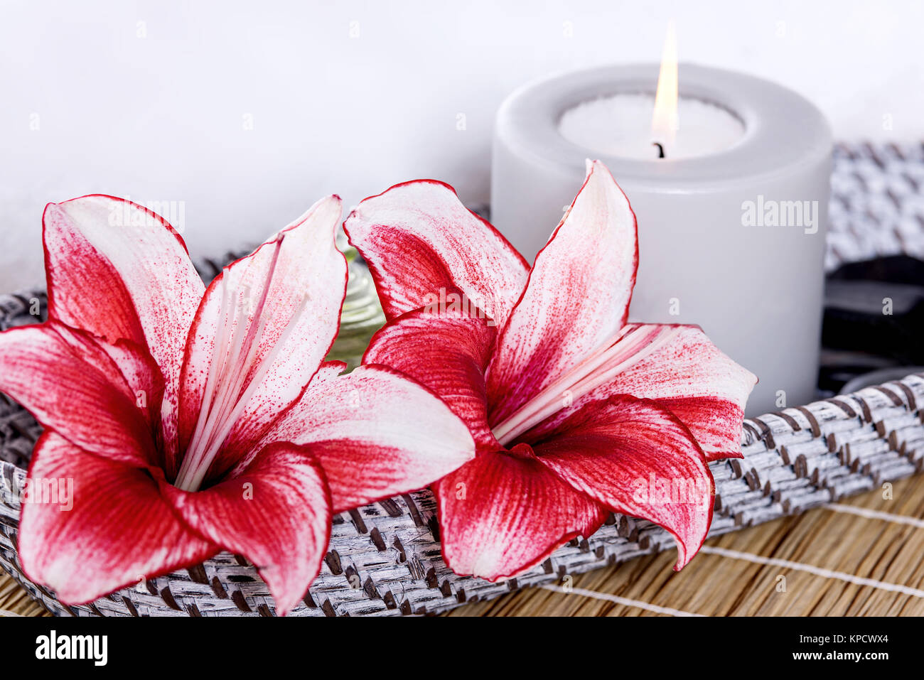 Lily flowers and scented lighted candle Stock Photo Alamy