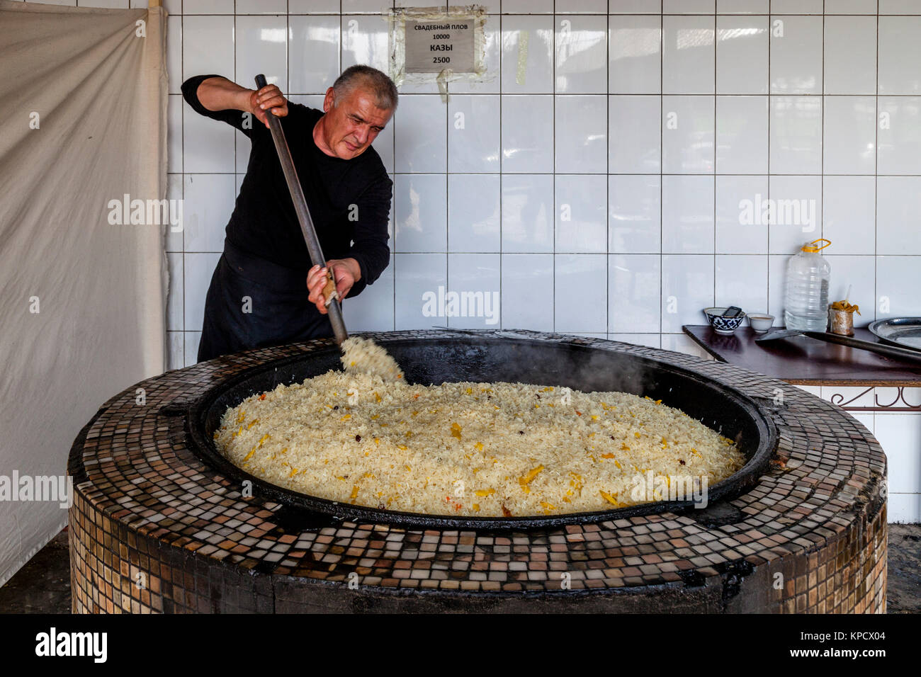 A Man Cooks Rice For PLOV (The National Dish) At The Central Asian Plov Centre, Tashkent, Uzbekistan Stock Photo