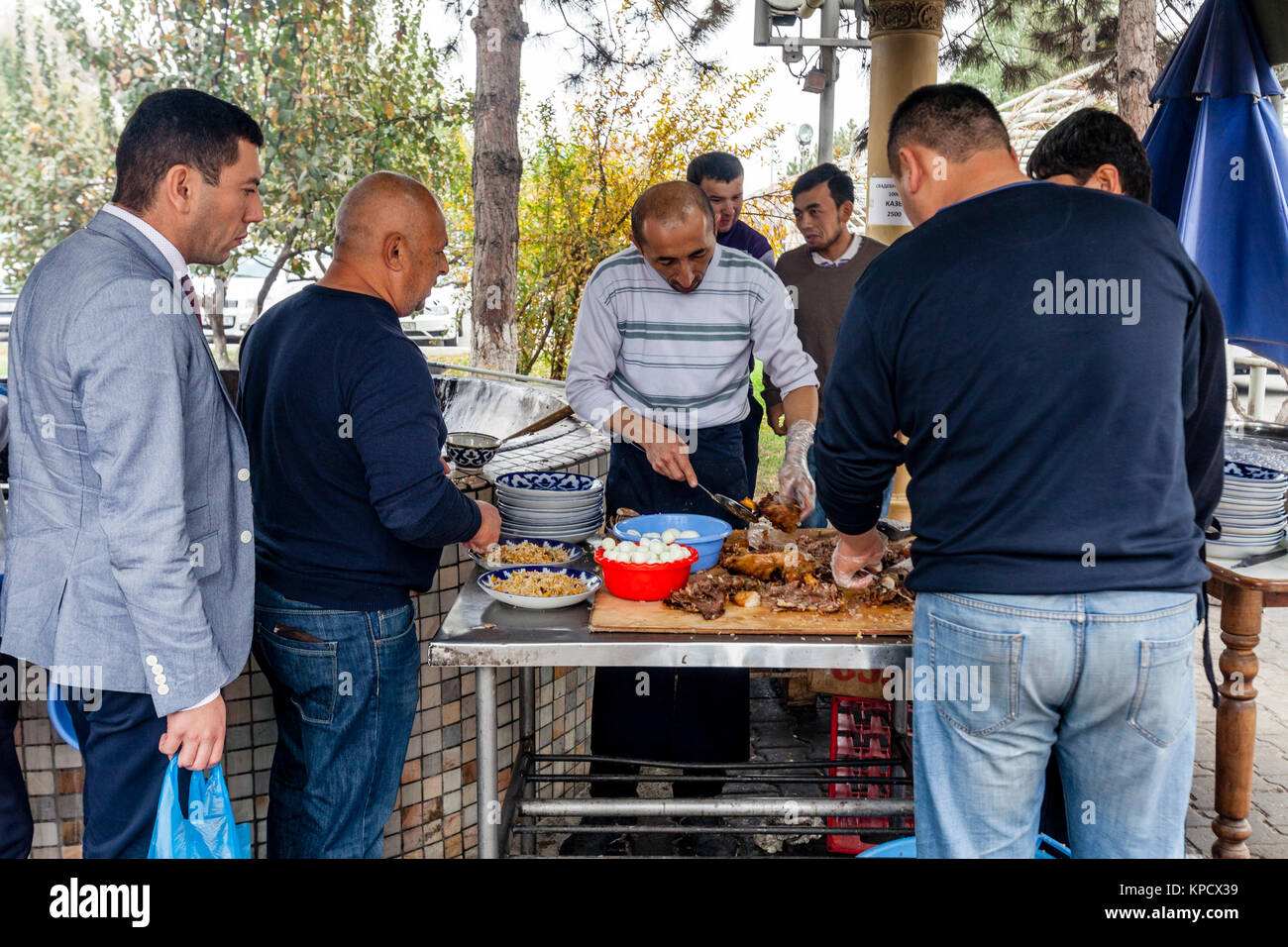 Men Cooking and Serving PLOV (The National Dish) At The Central Asian Plov Centre, Tashkent, Uzbekistan Stock Photo