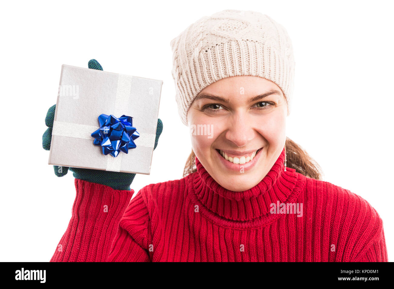 Happy smiling young woman holding a Christmas present wearing knitted ...