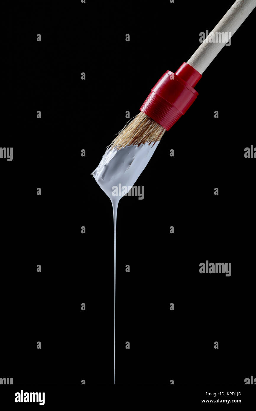 Paintbrush with white paint on a black background .Copy space Stock