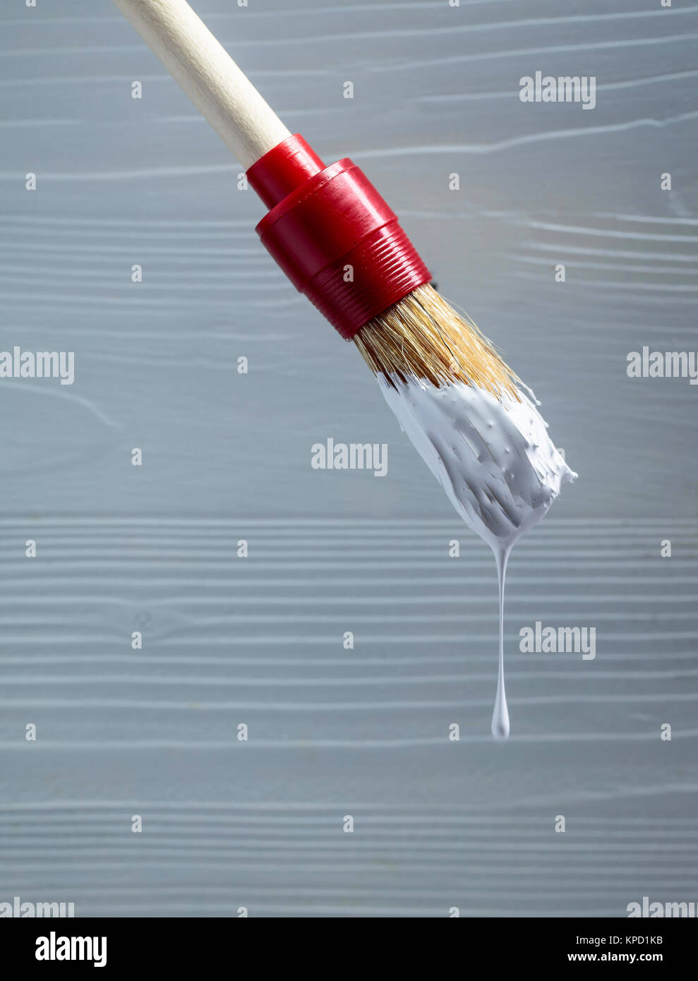 Paintbrush with white paint on a background of old wooden wall. Copy