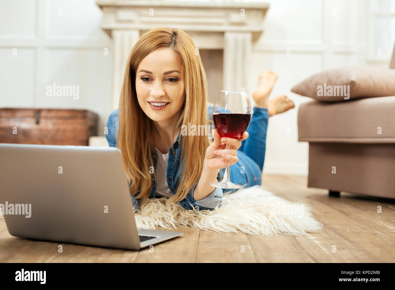 Joyful woman working and holding a glass of wine Stock Photo - Alamy