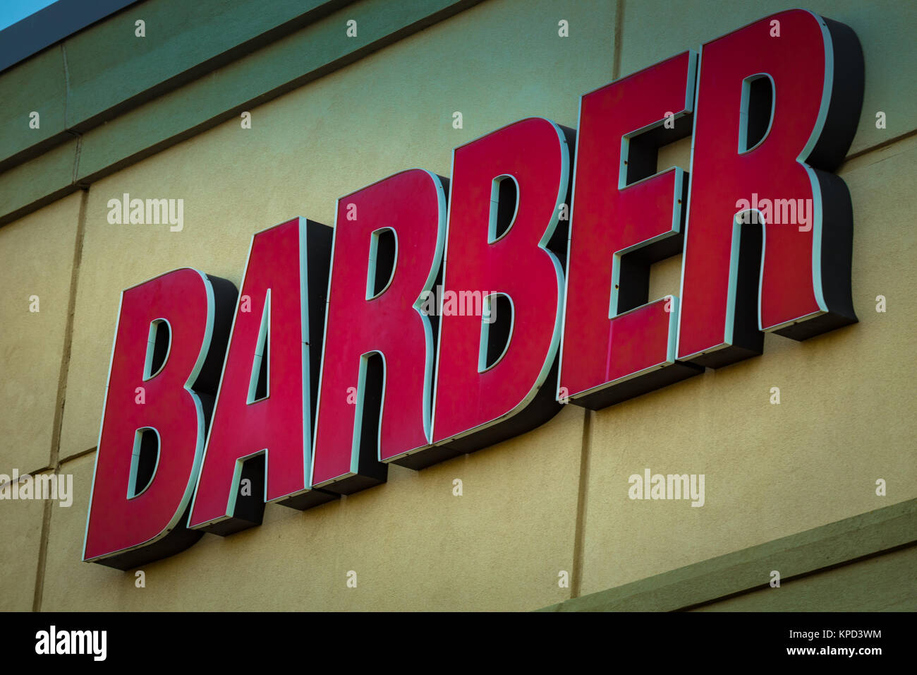 An exterior barber wall sign consiting of red letters only. Stock Photo