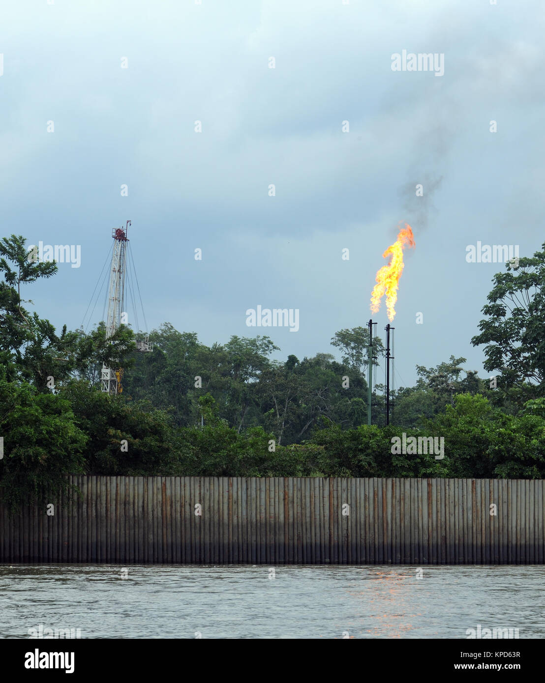 Unwanted natural gas is burnt at oil processing plant on the Napo River near Coca and the Yasuni National Park in Amazonian Ecuador. Virgin forest is Stock Photo
