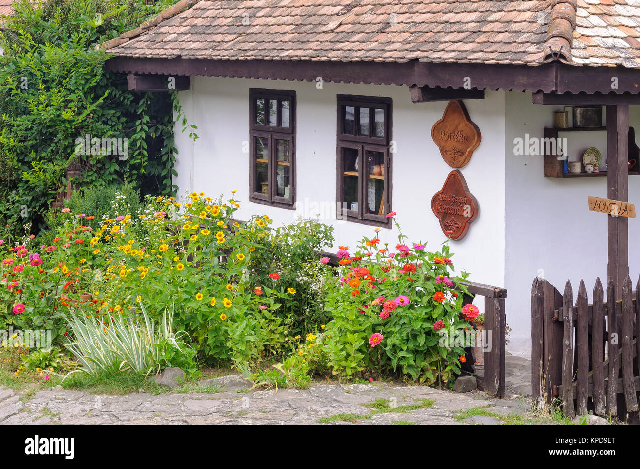 Flowers in front of a traditional Paloc farmhouse in the UNESCO World Heritage village - Holloko, Hungary Stock Photo