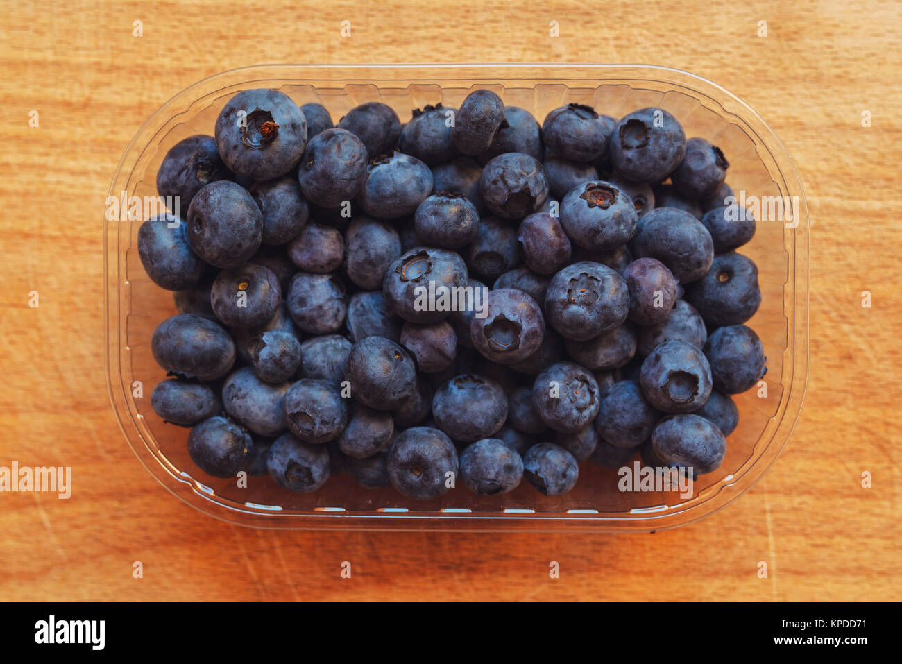 Blueberries myrtilles in plastic container box on wooden table Stock Photo