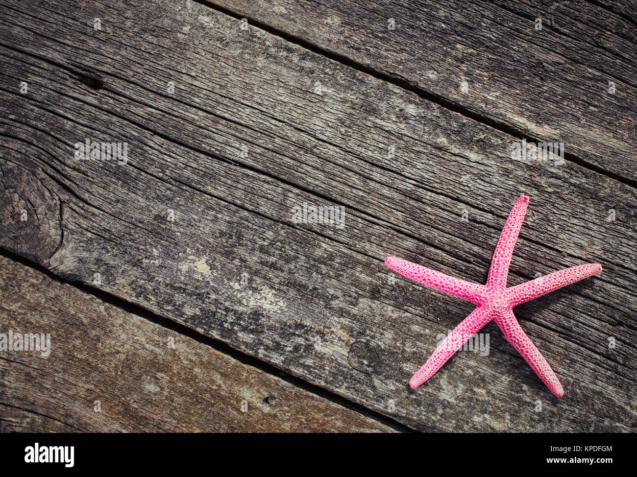 Starfish laying on a pattern on wooden background Stock Photo - Alamy