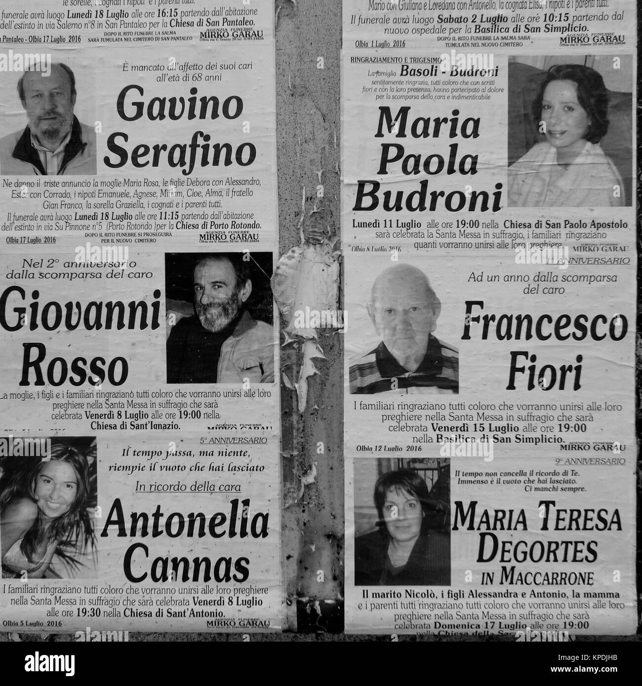 Obituaries glued on a wall in Olbia center, Sardinia, Italy Stock Photo