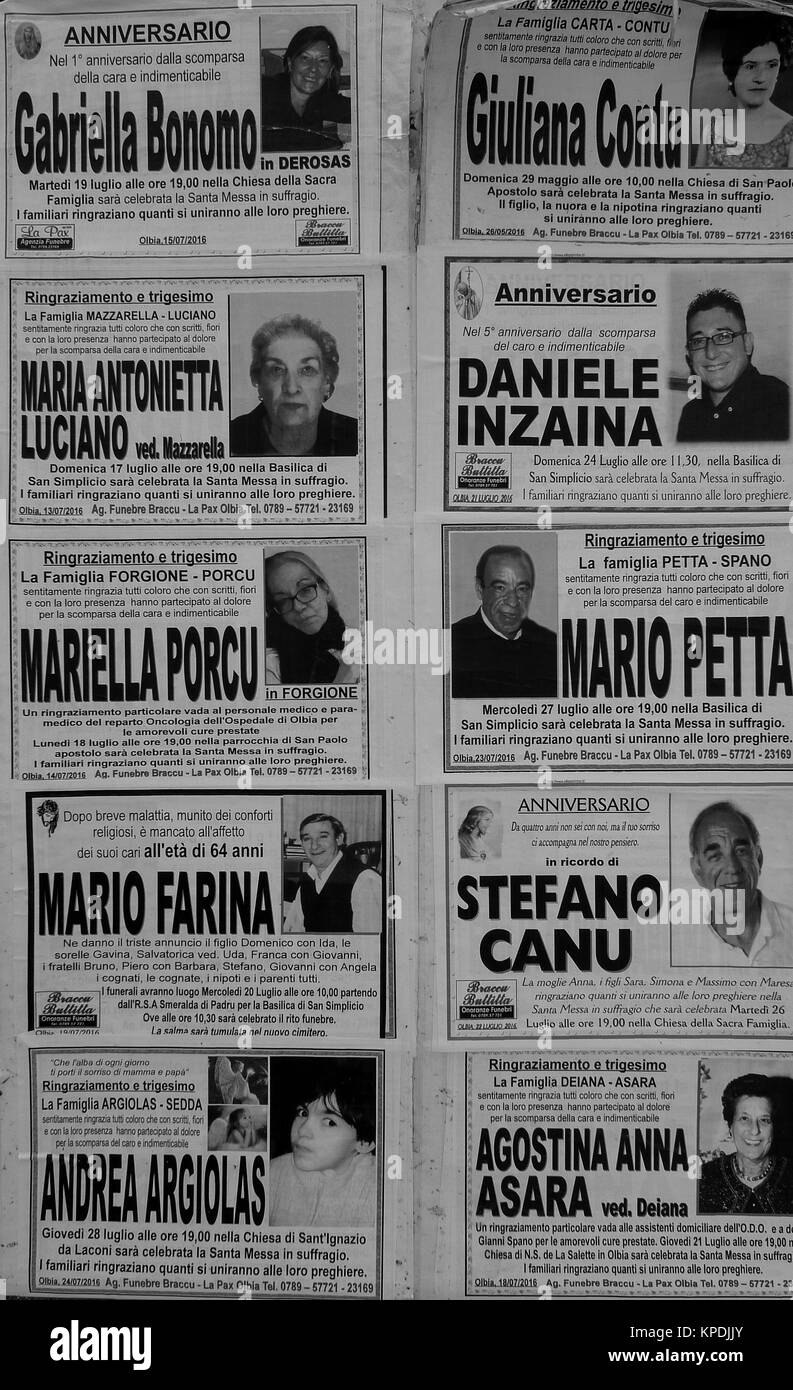 Obituaries glued on a wall in Olbia center, Sardinia, Italy Stock Photo