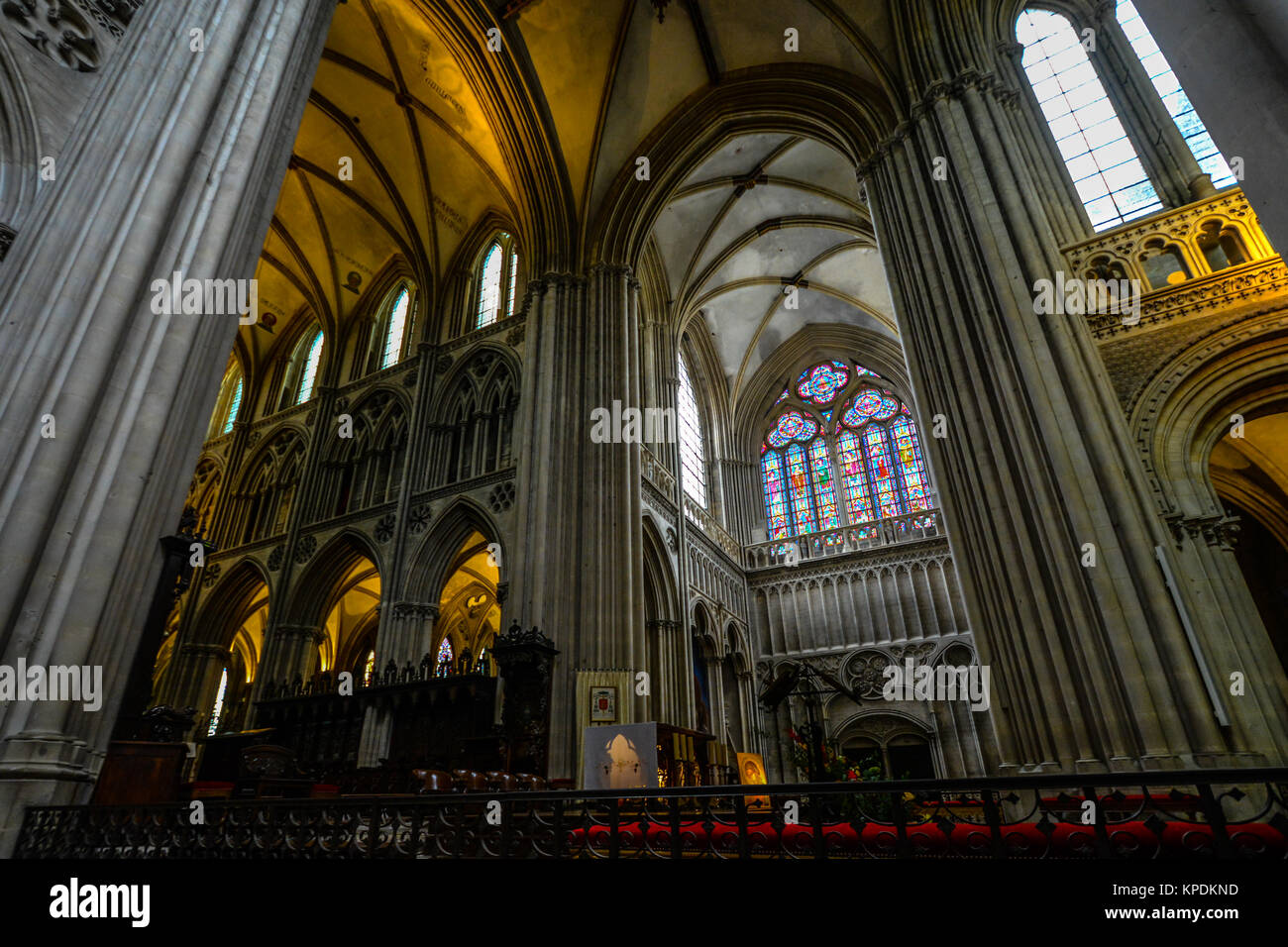 The interior transept, nave, ambulatory of the Bayeux Cathedral in Normandy France with beautiful gothic stained glass windows Stock Photo