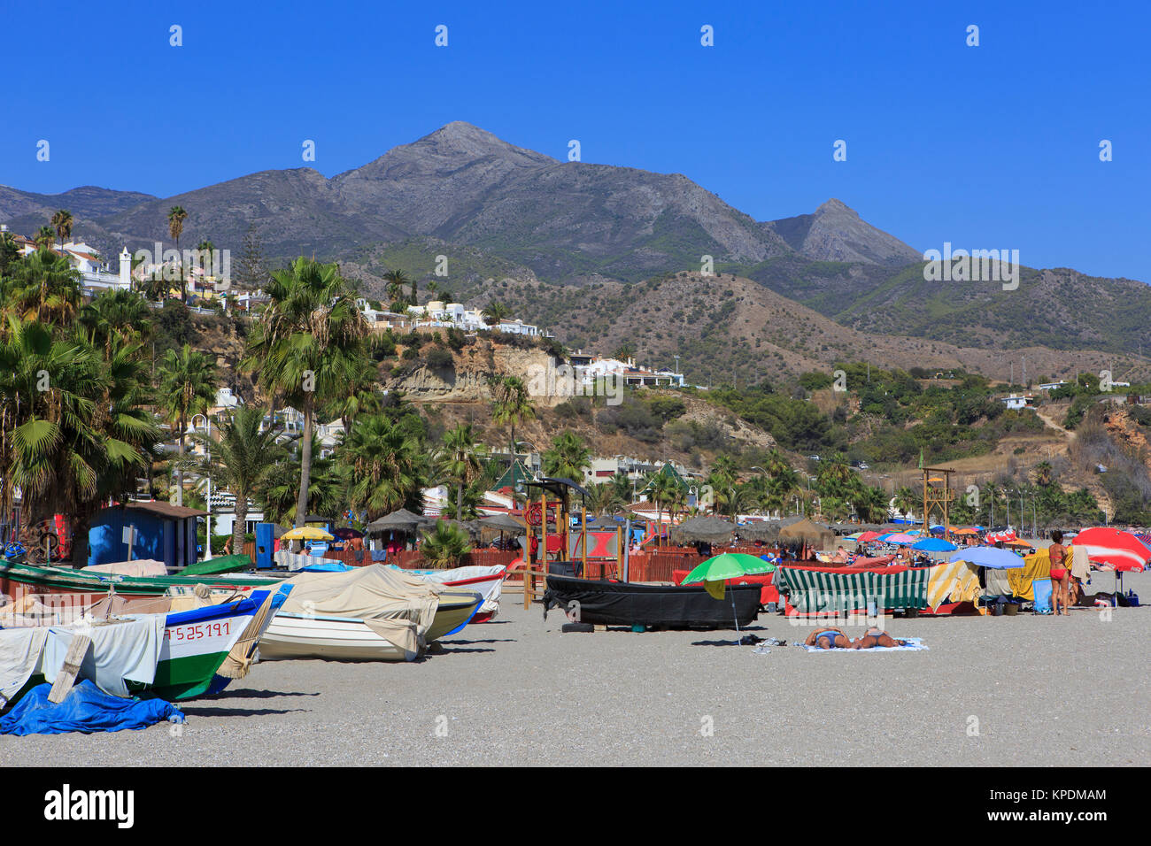 Fishing boats and tourist at Burriana Beach (Playa de Burriana) in Nerja on the Costa del Sol in the province of Malaga, Spain Stock Photo