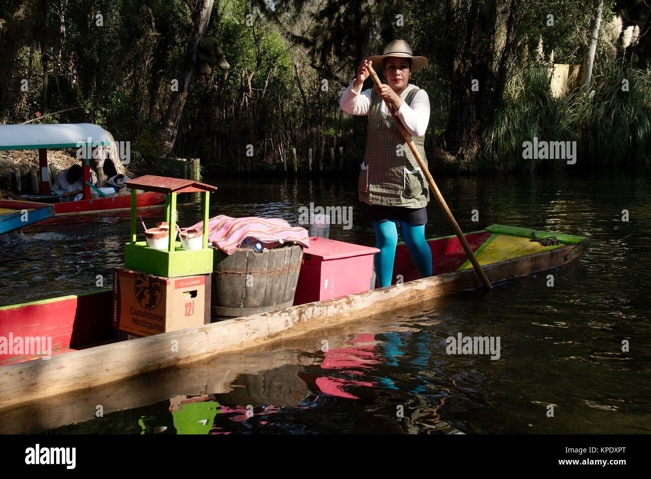 Xochimilco, Mexico City, Mexico - 2017: A woman in a trajinera (a local type of boat) sells cold beverages to people in other trajineras on a canal Stock Photo