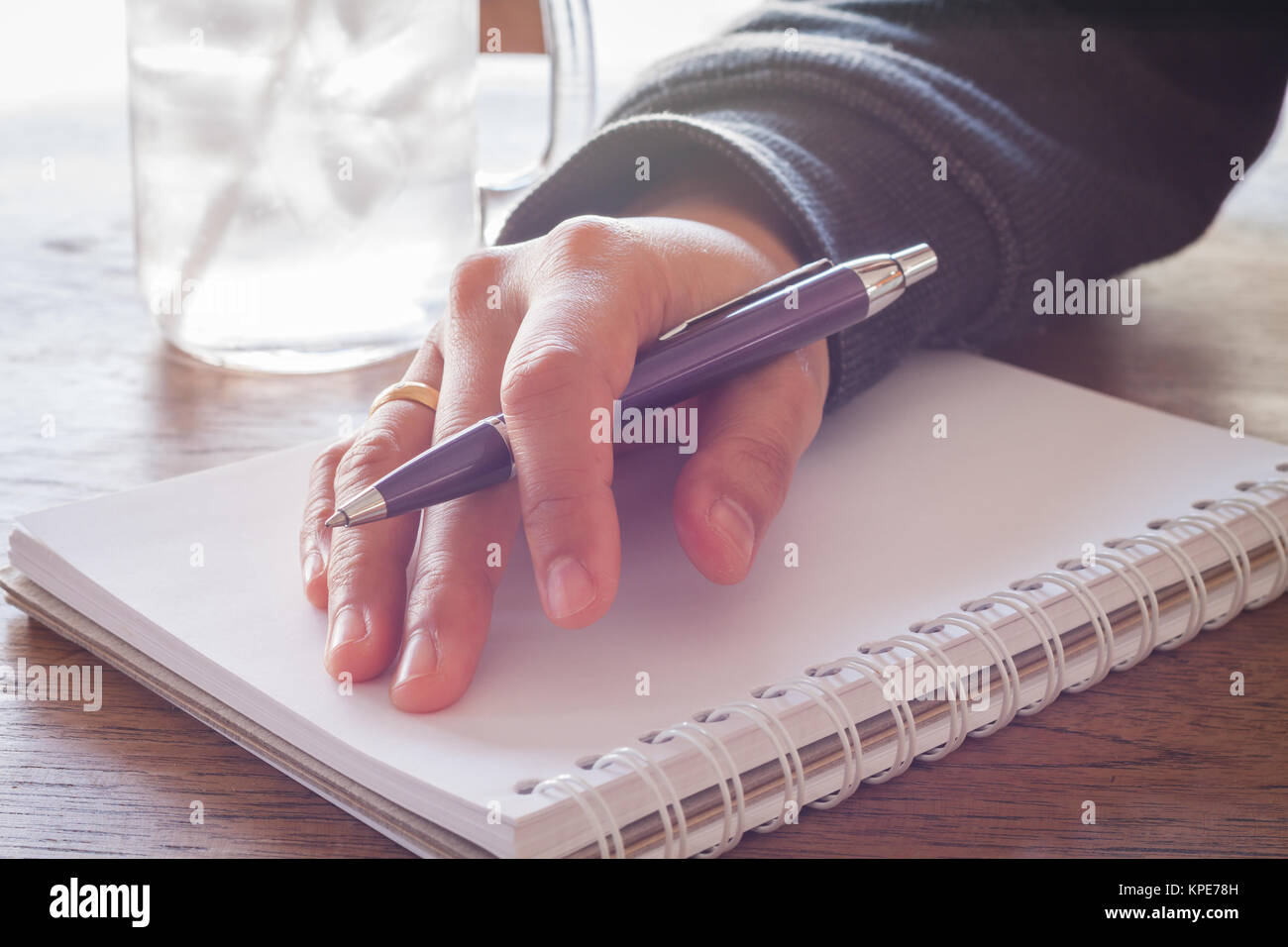 Woman hand with pen writing on notebook Stock Photo - Alamy
