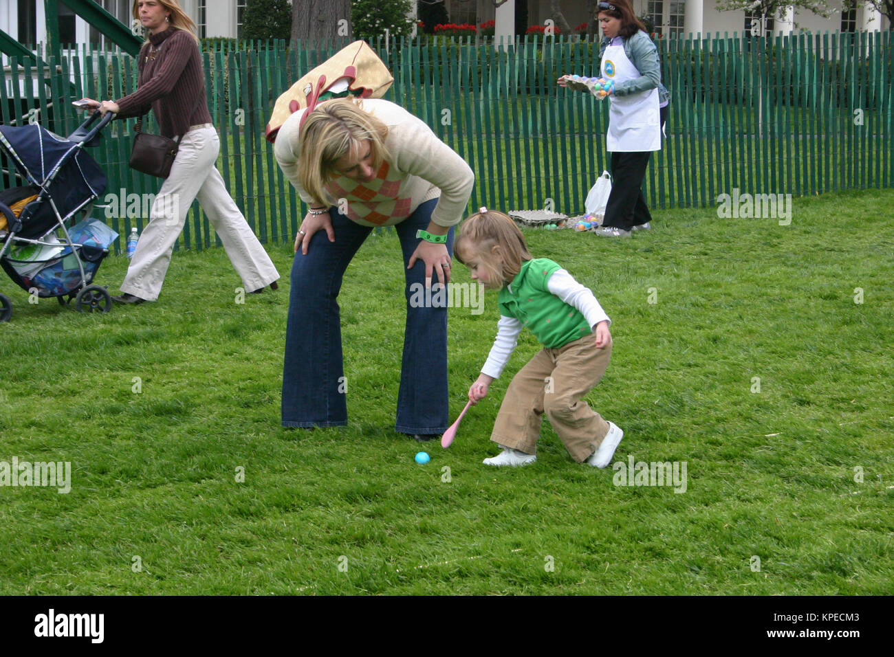 Mother and child rolling egg with spoon at annual egg roll celebrating Easter on the White House lawn in Washington DC, USA. Stock Photo