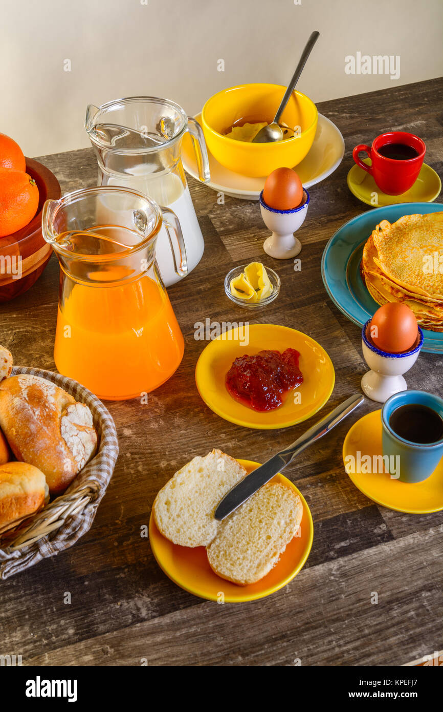 table of breakfast full set with eggs, pancakes, bread, jam ,juice and ...
