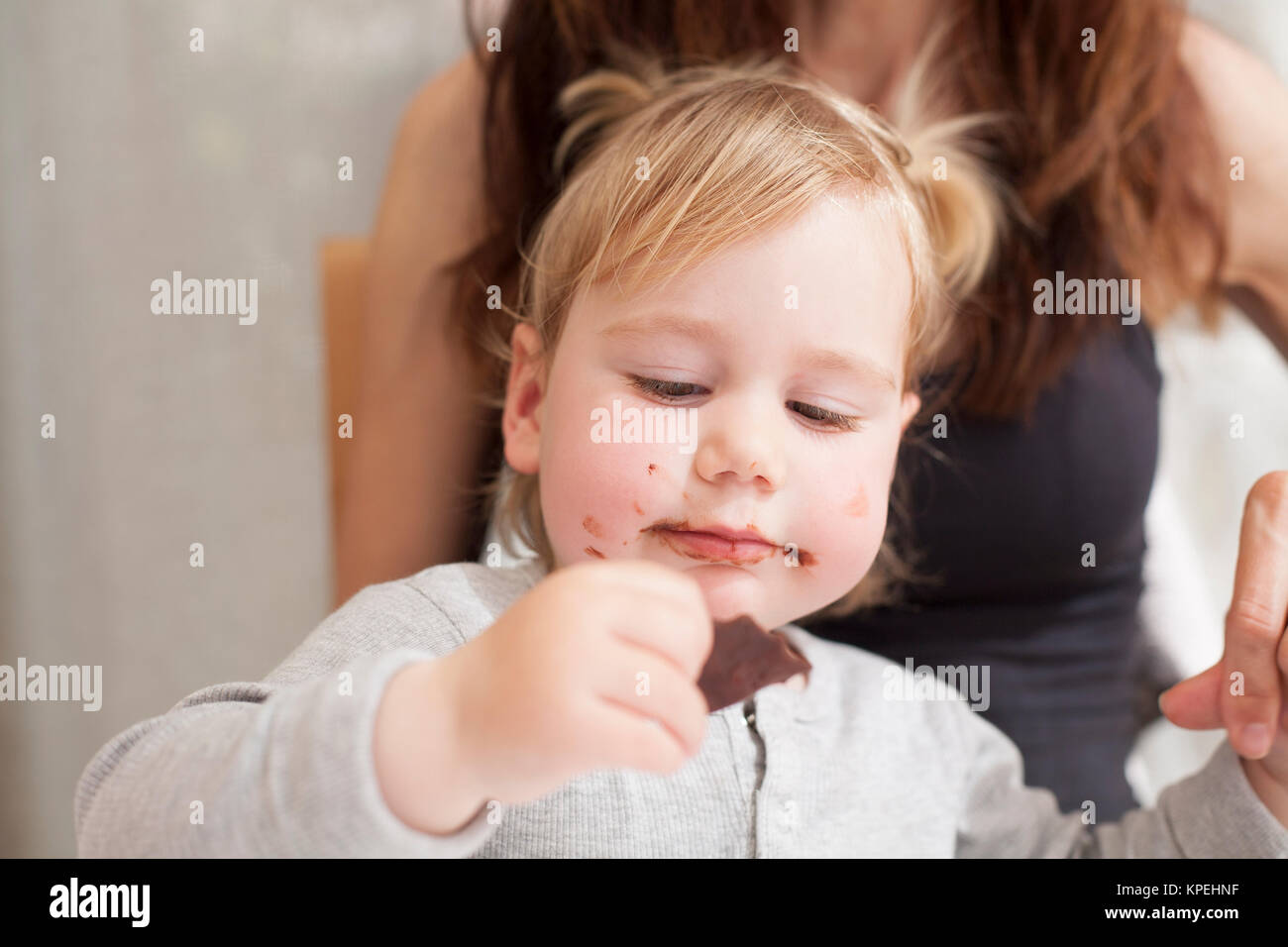 baby with mother eating chocolate Stock Photo Alamy