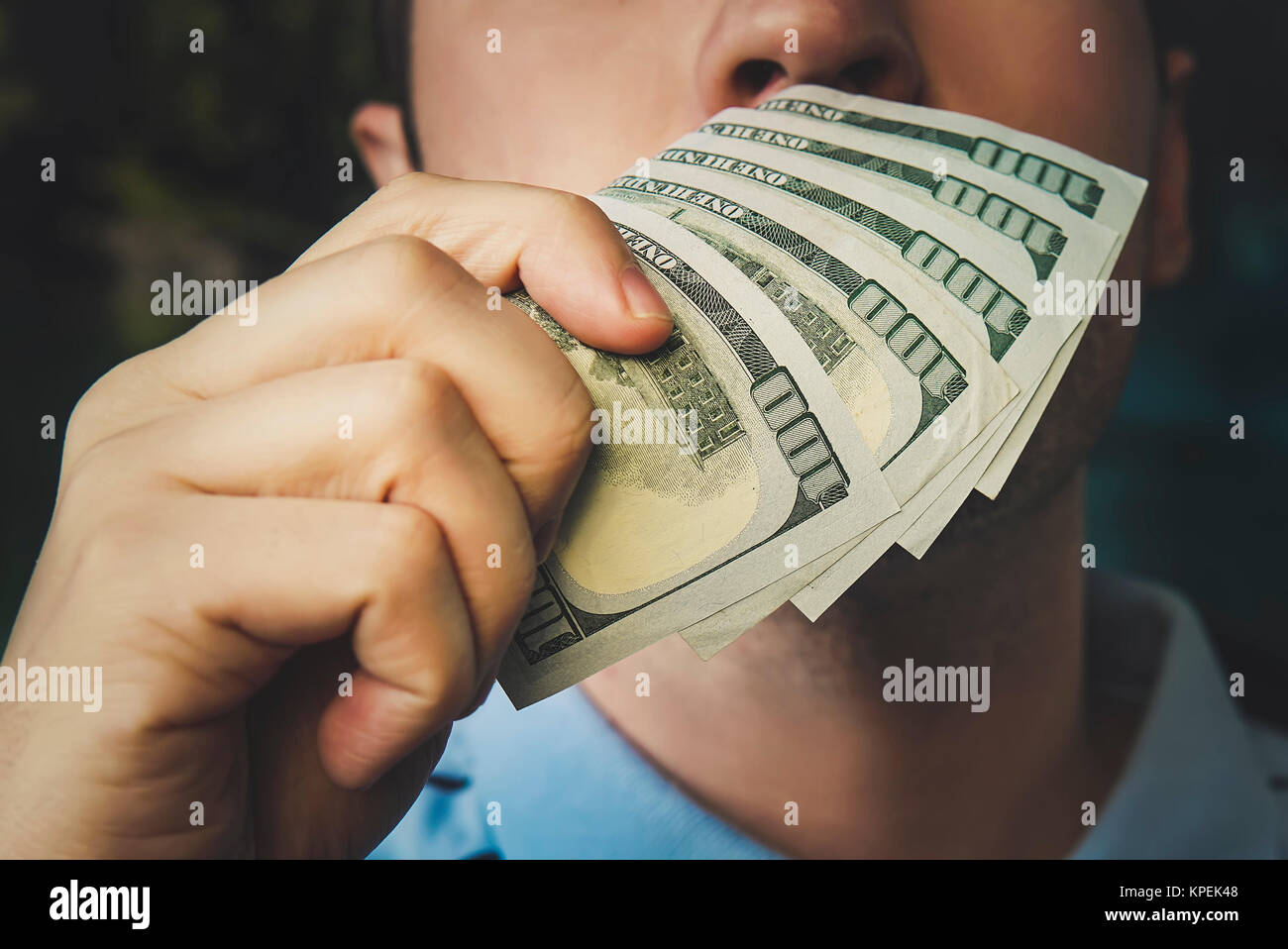 Handsome young businessman holding and smelling money. the