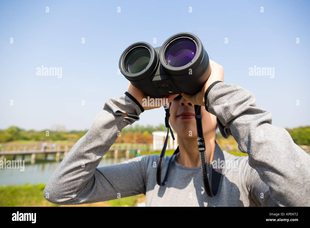 Woman looking though binocular for bird watching Stock Photo - Alamy
