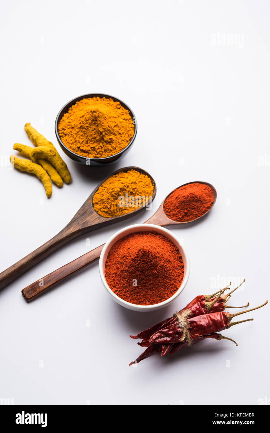 heap of turmeric and red chilli powder in a ceramic bowl on a white or