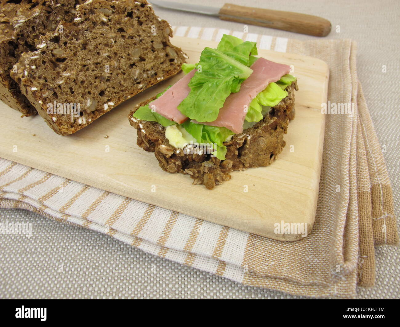 topped brown bread with smoked ham and lettuce Stock Photo