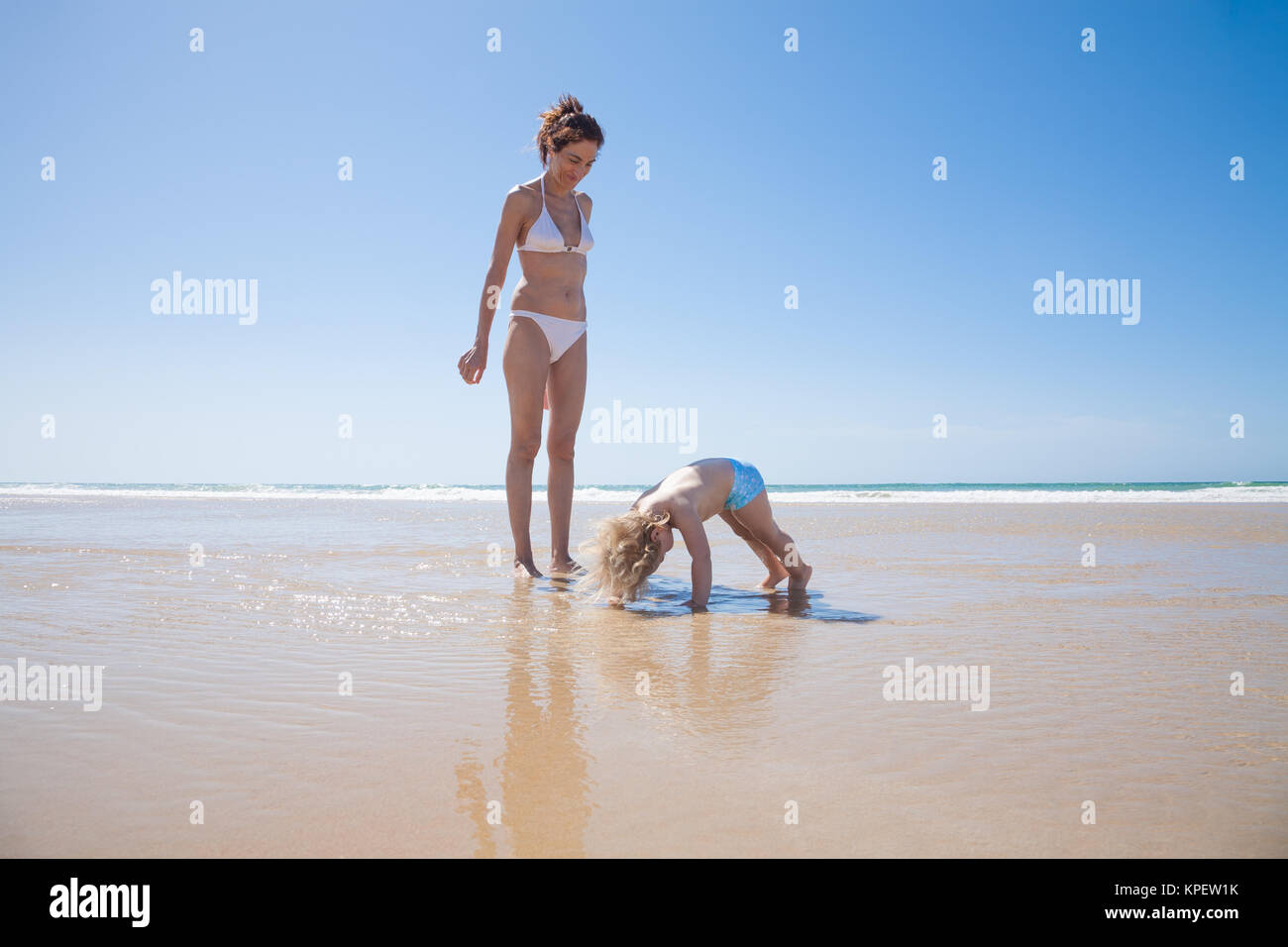 baby pushingup at seashore with mother Stock Photo Alamy