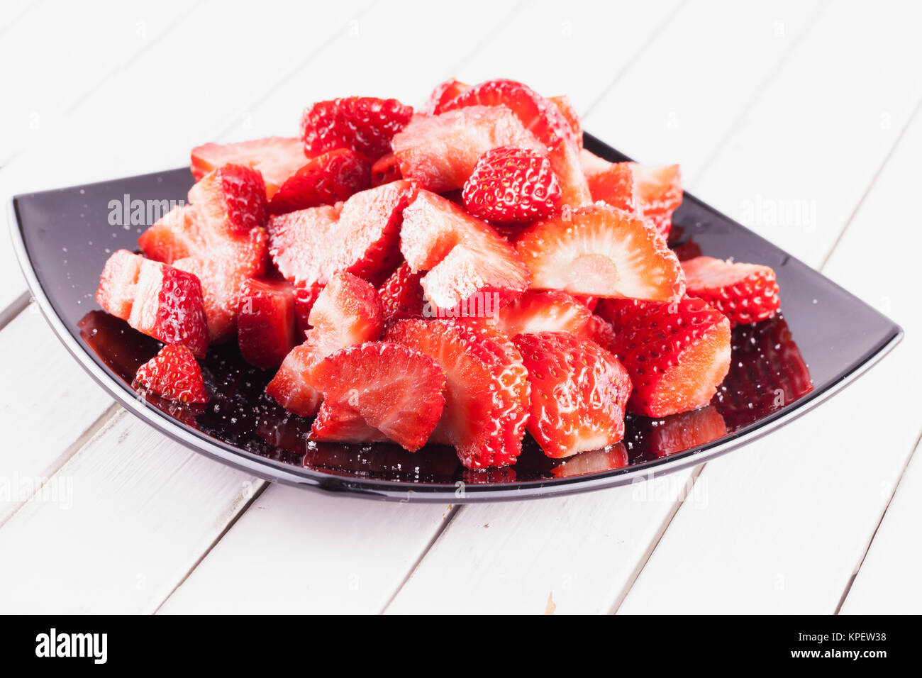 Strawberries over black plate Stock Photo - Alamy