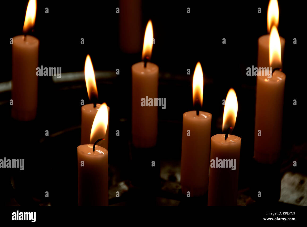 Mehrere Kerzen leuchten im Dunkeln Stock Photo