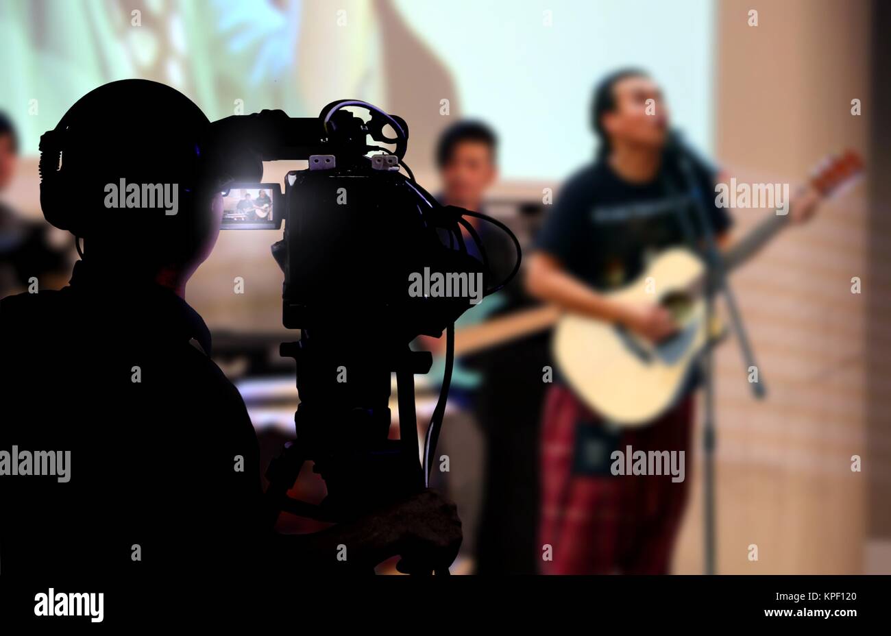 Cameraman shooting a live concert on stage Stock Photo