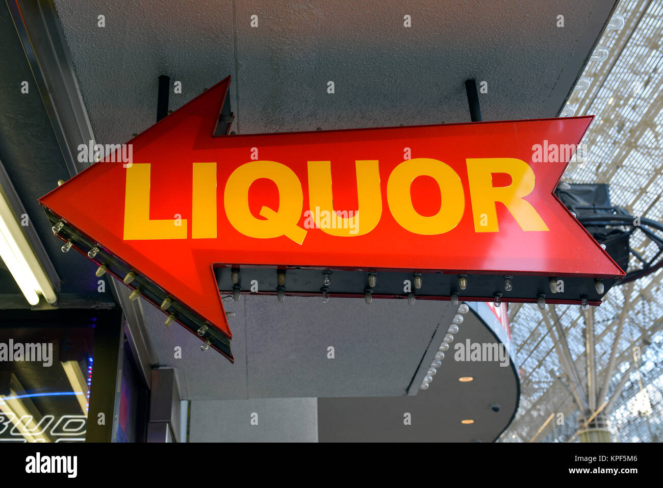 An arrow sign pointing the way to a liquor store. Stock Photo