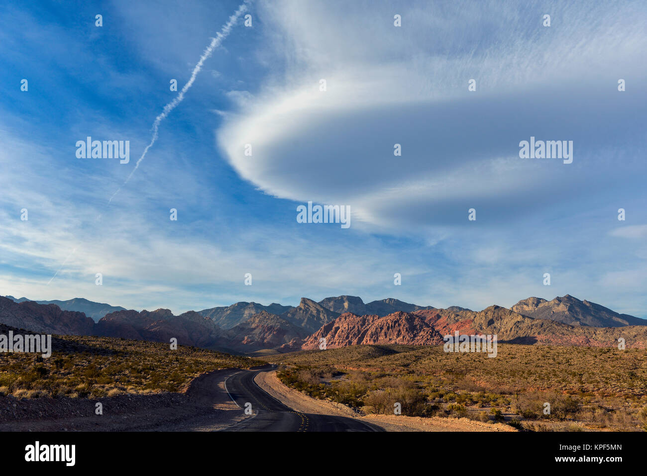 Red Rock Park Nevada landscape with desert, road, lenticular clouds and mountains Stock Photo