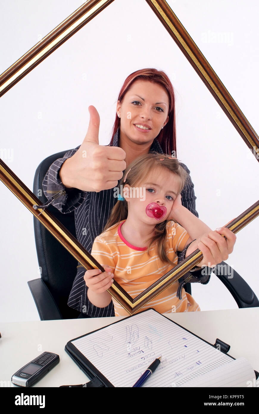 Symbolbild Karrierefrau und Mutter, erfolgreiche Geschaeftsfrau mit Tochter am Schreibtisch - sucessful businesswoman with daughter Stock Photo