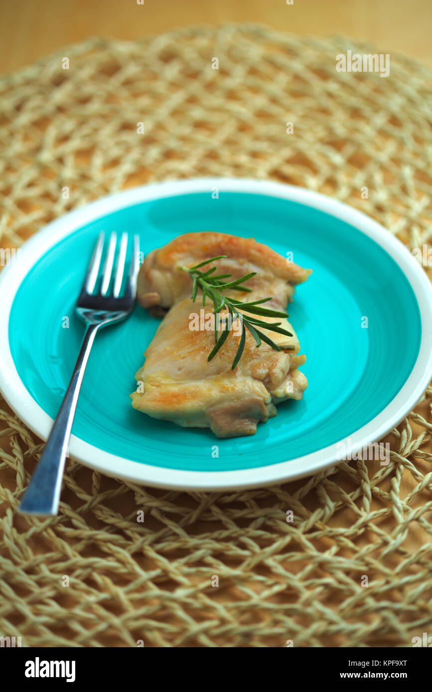 chicken cooked in a pan with olive oil and rosemary sprig Stock Photo
