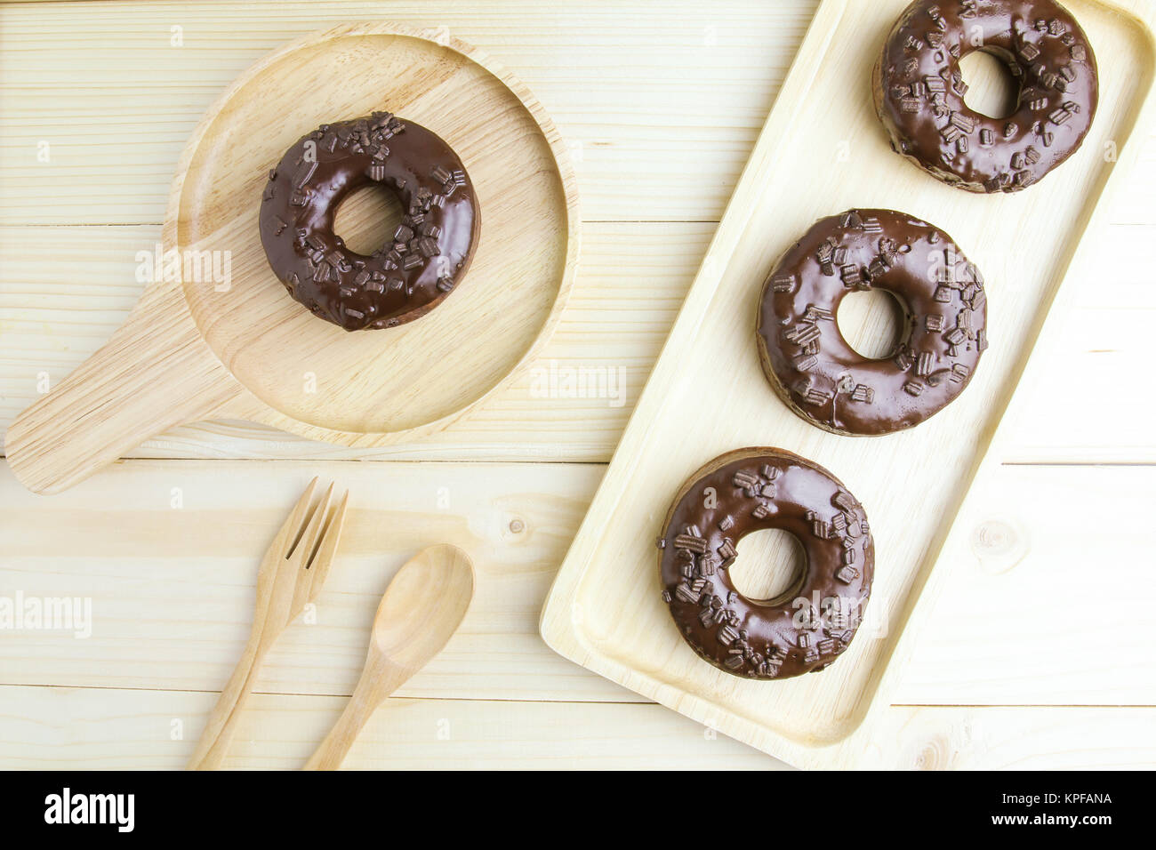 Chocolate Donuts on wooden plate on wooden background Stock Photo - Alamy