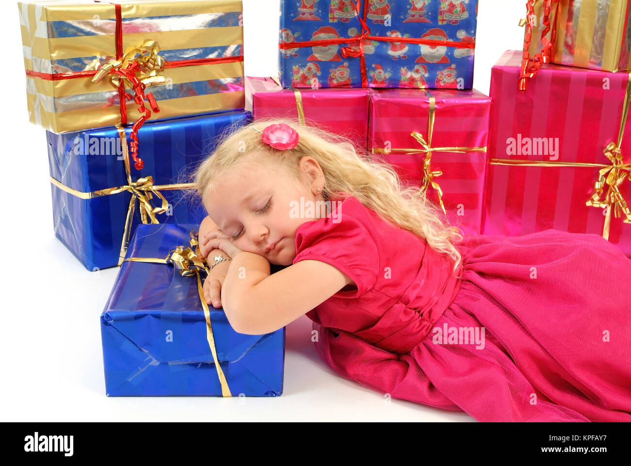 Symbolbild Warten auf Weihnachten, Maedchen schlaeft zwischen geschenken - girl sleeps among christmas presents Stock Photo