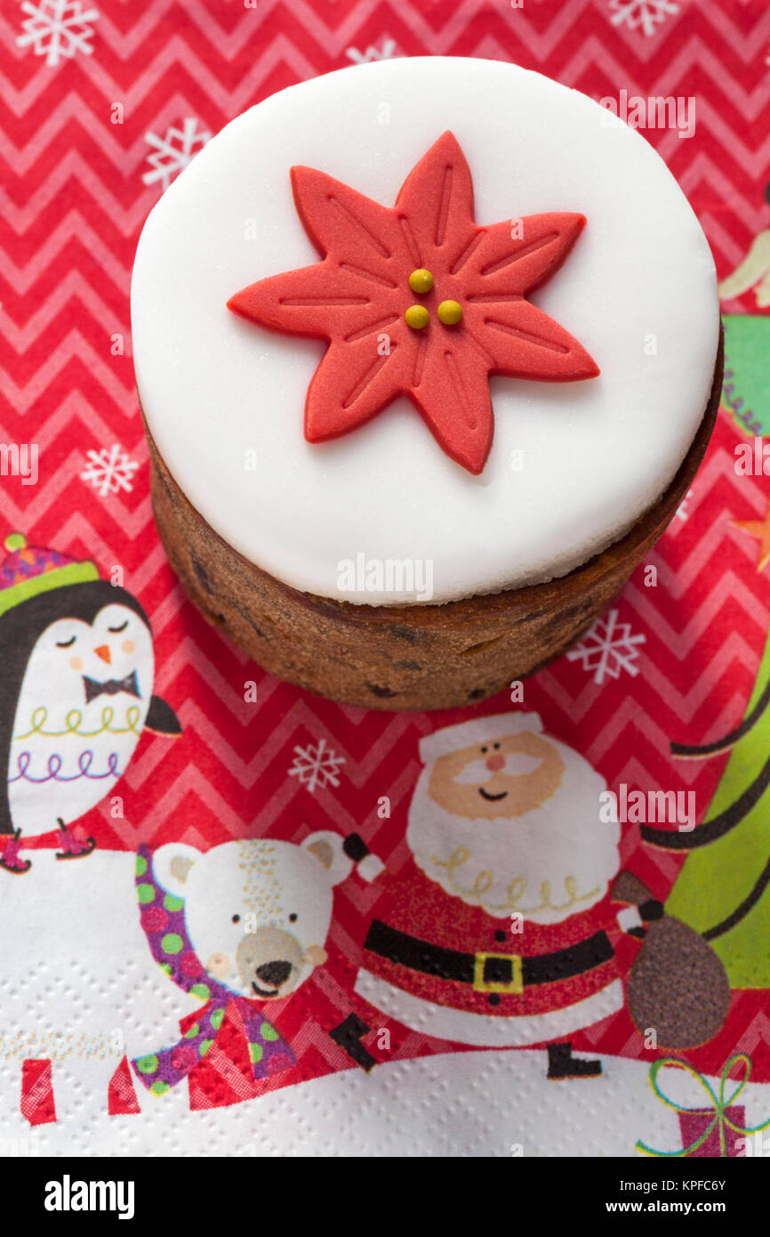 Tesco mini top iced Christmas cake - rich fruit cake with glace cherries, topped with marzipan and decorative icing set on Christmas serviette Stock Photo