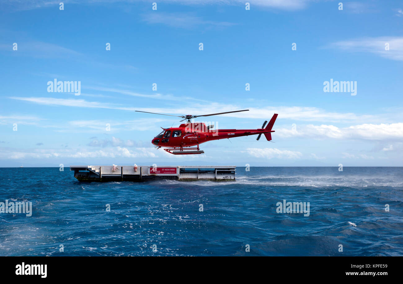 A  AS350 Squirrel Helicopter, operated by Nautilus Aviation, flies tourists over Hastings Reef, in the Coral Sea 30 nautical miles from Cairns. Stock Photo