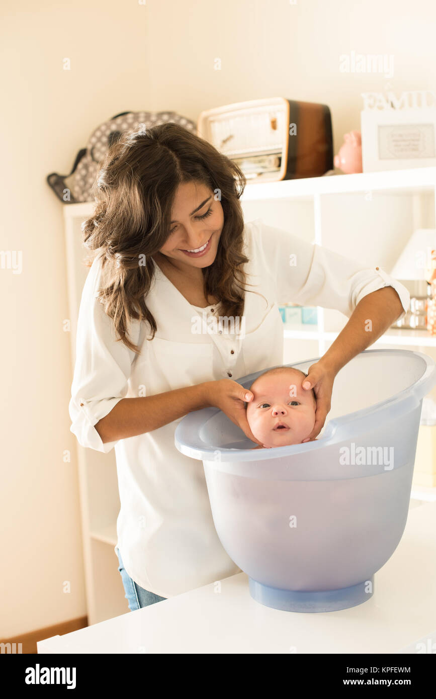 Mother washing a newborn baby in a bath tub Stock Photo Alamy