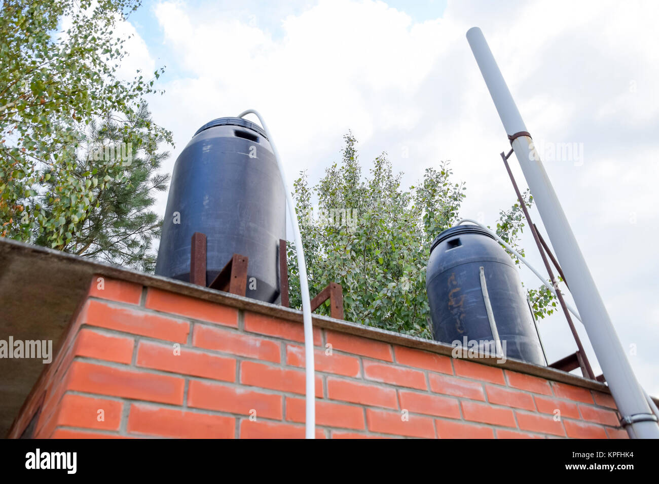 Black plastic barrels on a summer shower. Barrels for heating water from the sun Stock Photo Alamy