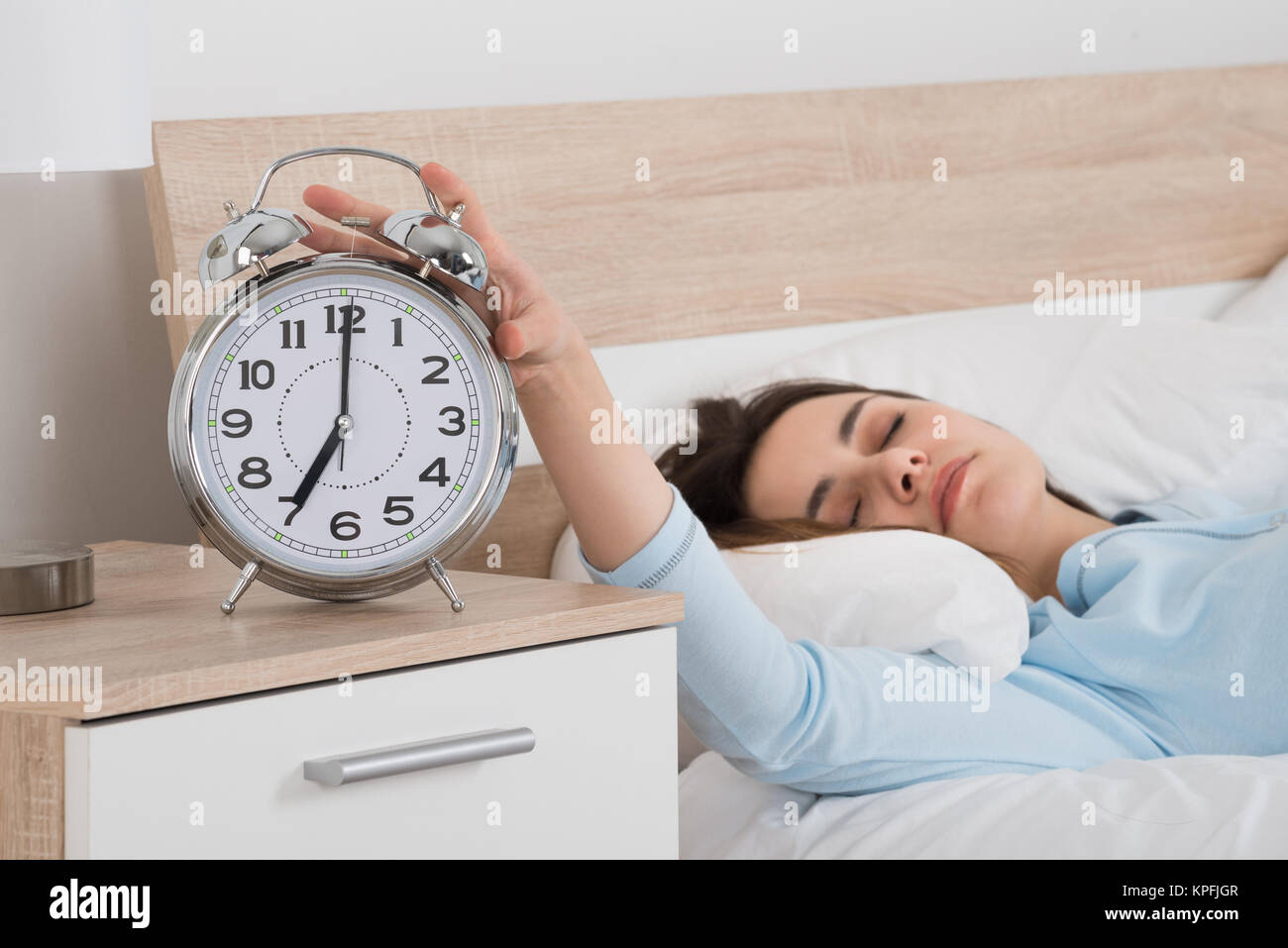Woman Turning Off Alarm While Sleeping On Bed Stock Photo Alamy