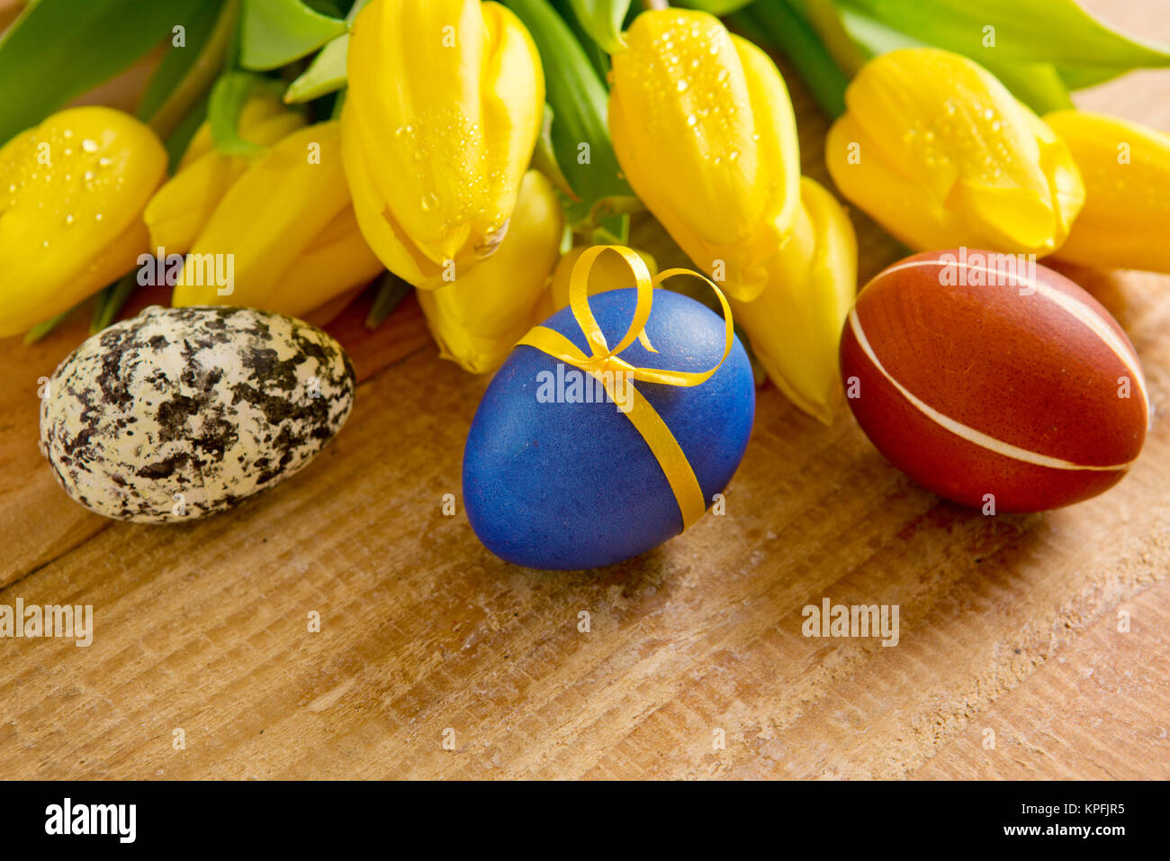 Colorful Easter eggs and tulips isolated on wood Stock Photo - Alamy