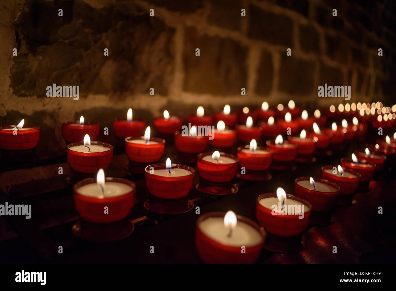 Sacrificial candles/tealights burn in a church Stock Photo Alamy
