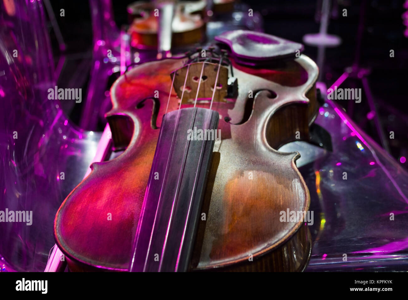 violin in vintage style on chair colorful background Stock Photo