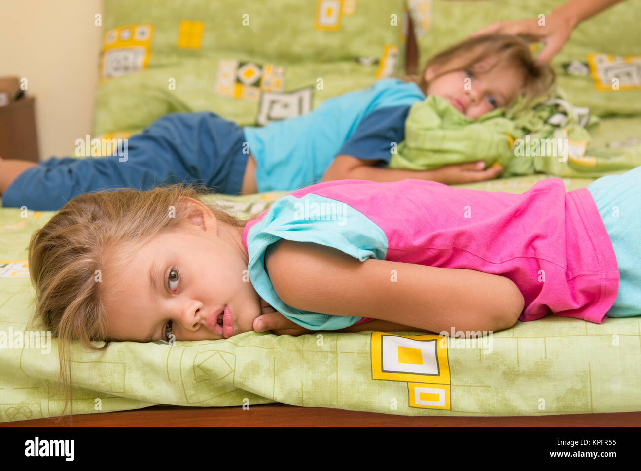 Two girls lie on a bed on the opposite sides Stock Photo Alamy