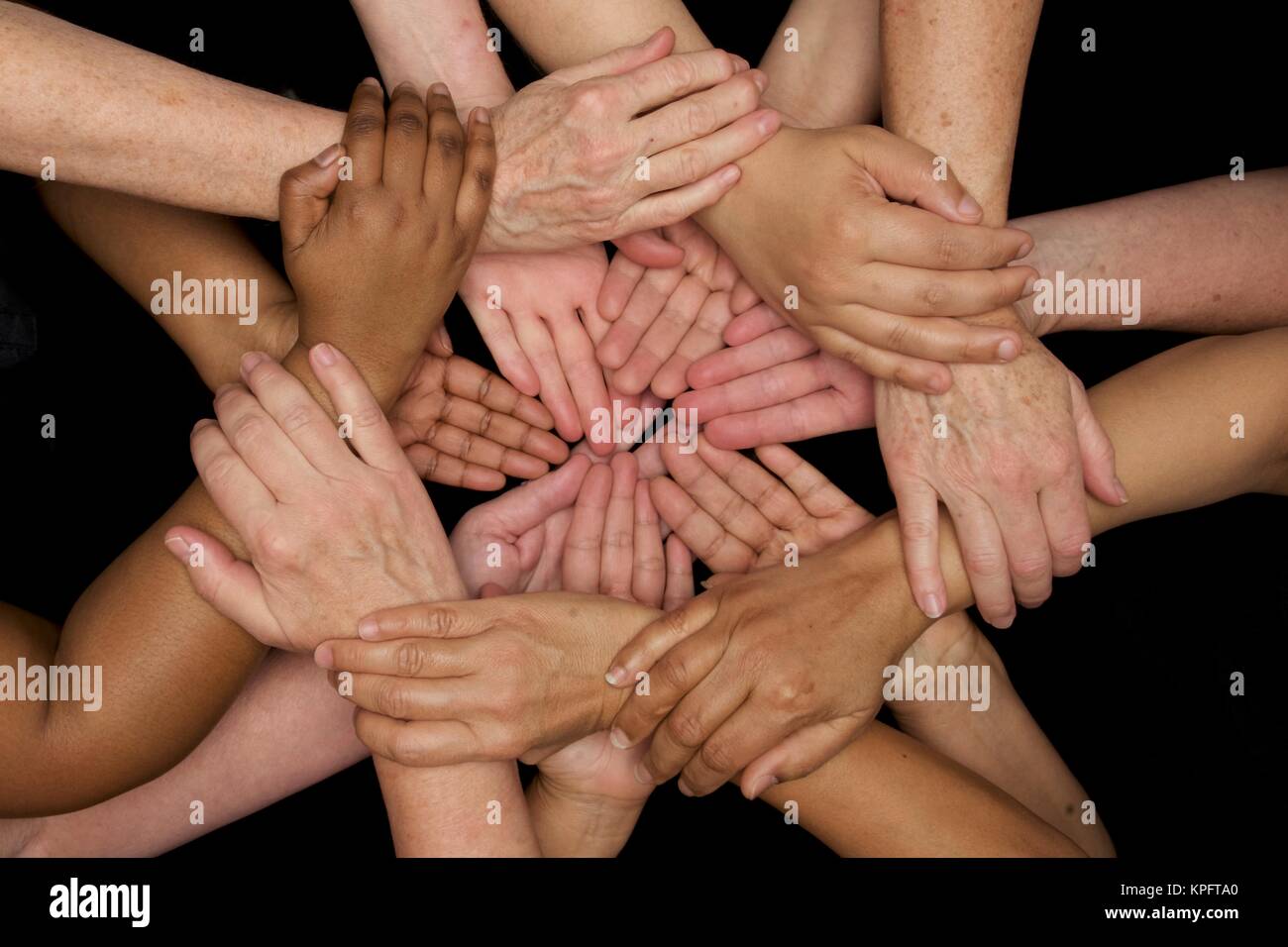 hands of many colors unite in harmonious diversity  and heart felt team work Stock Photo