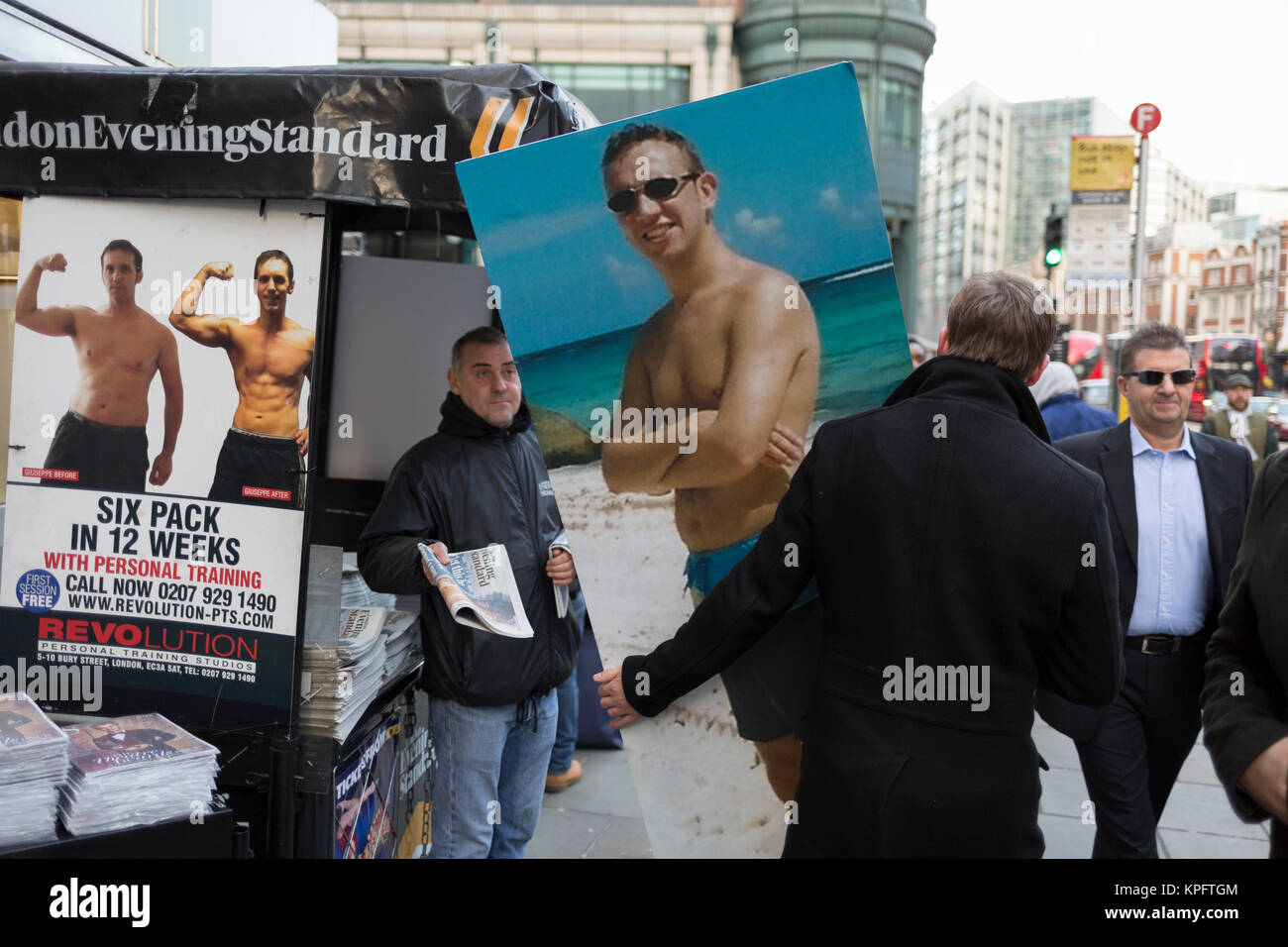 An employee from an insurance company walks through the City of London, visiting specific addresses relevant to the man appearing in a beach portrait whose 50th birthday it is, part of a creative and fun idea for the company's Christmas party, on 14th December 2017, in the City of London, England. Stock Photo