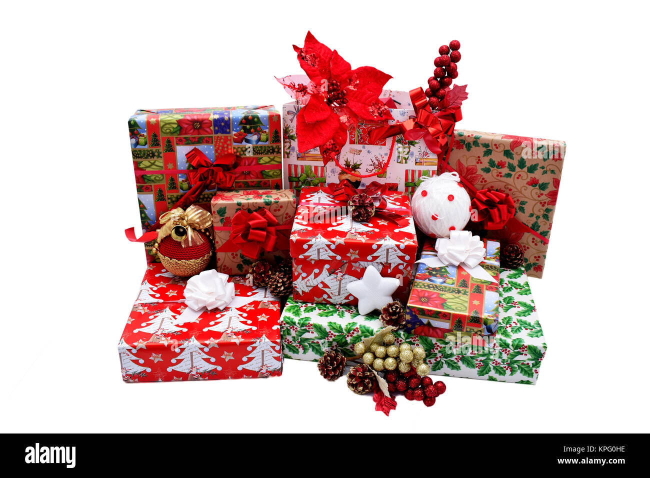 Christmas gifts in boxes and bags, wrapped in themed paper. Decorations with red decorative flowers, Christmas white and golden globes and pine cones Stock Photo