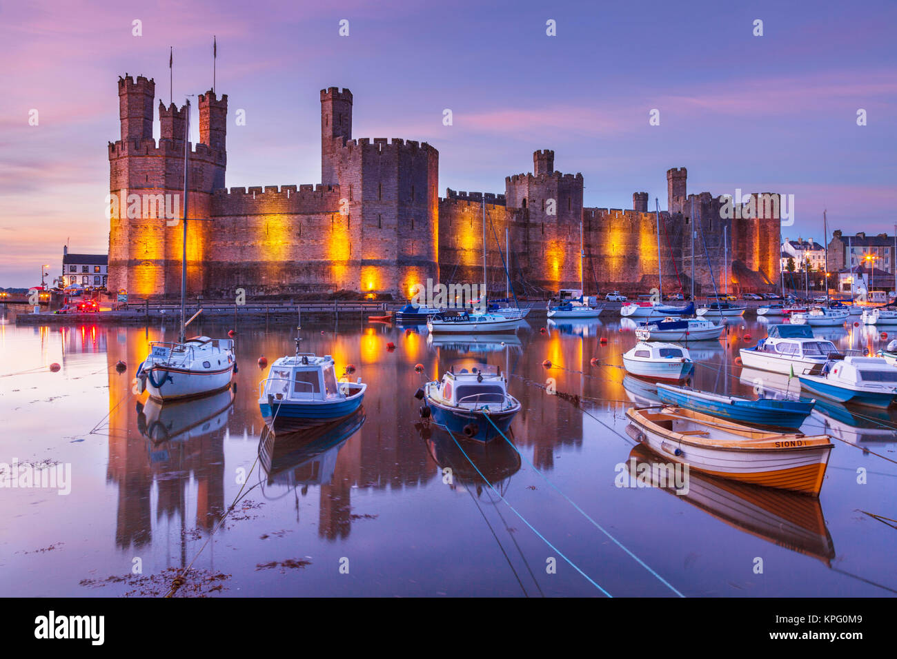 Caernarfon castle wales caernarfon north wales Caernarfon north wales illuminated at night  Caernarfon bay estuary Gwynedd north wales gb uk Stock Photo